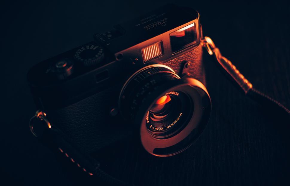 Free Image of Vintage black camera close-up with dramatic lighting on dark surface. 