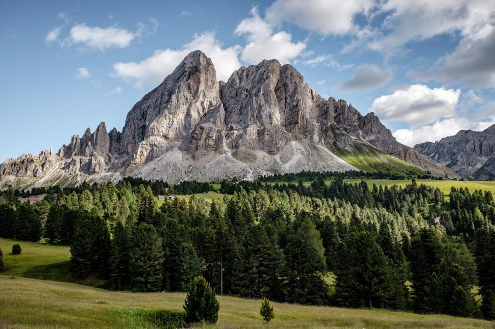 Free Image of A panoramic view of rocky mountain peaks surrounded by lush trees. 