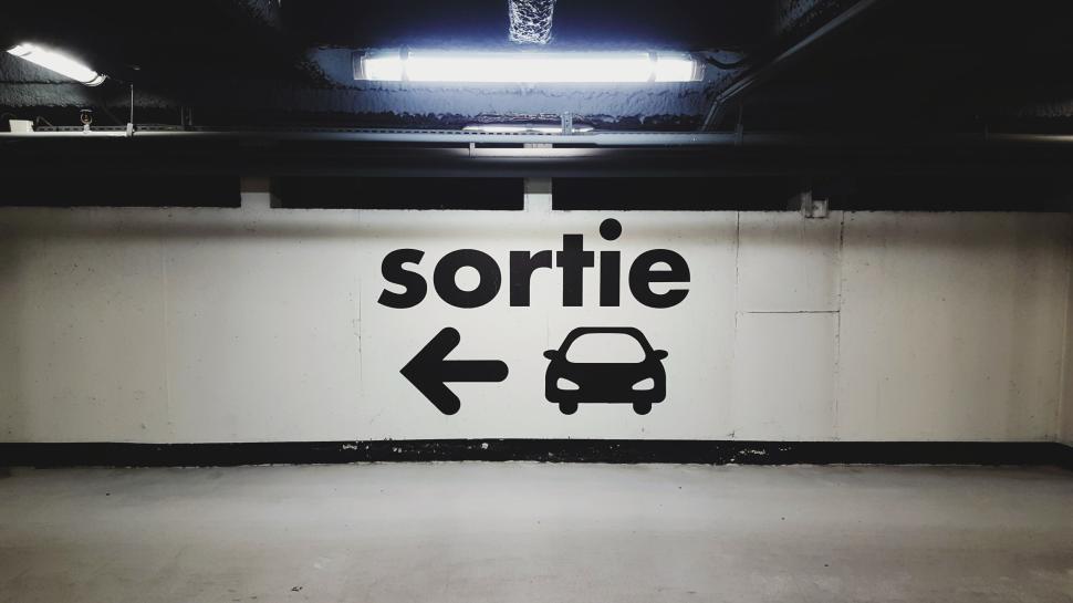Free Image of Underground parking exit sign with directional arrow and car icon 