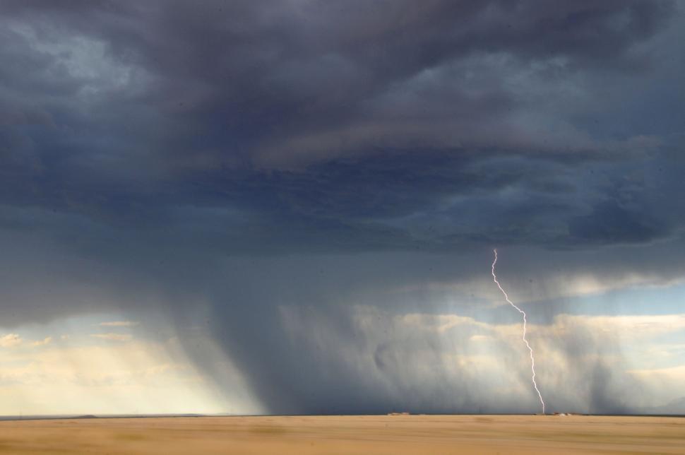Free Image of Thunderstorm on the horizon with visible rain shaft and lightning 