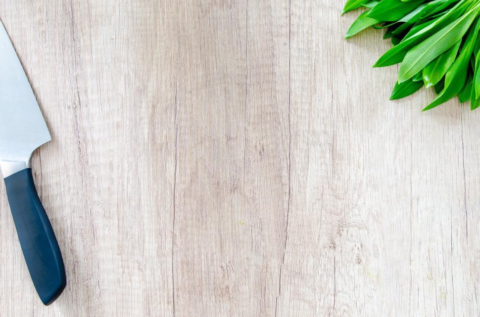 Free Image of Wooden countertop with chef s knife and fresh green herbs 