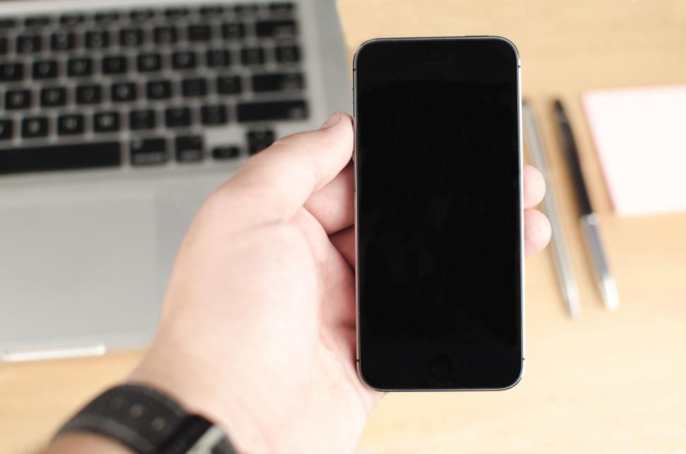 Free Image of Close-up of a hand holding a smartphone with a blank black screen 