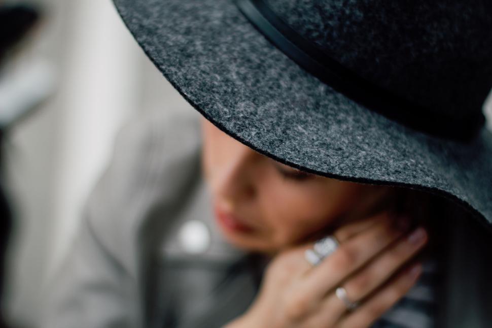 Free Image of Person wearing gray hat and touching neck – close-up with focus 