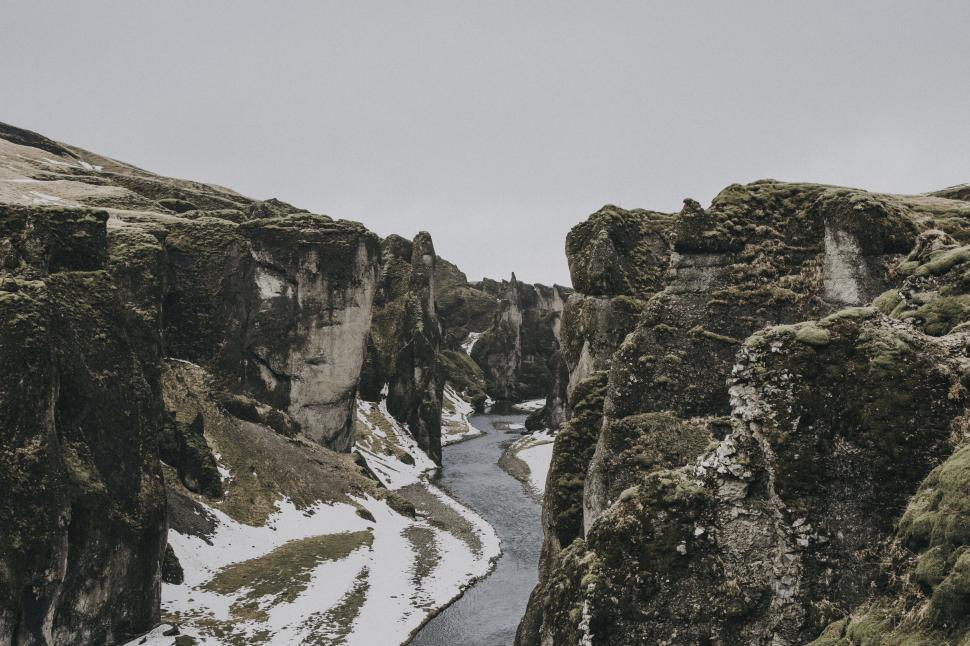 Free Image of Rugged canyon landscape with winding river and sparse vegetation 