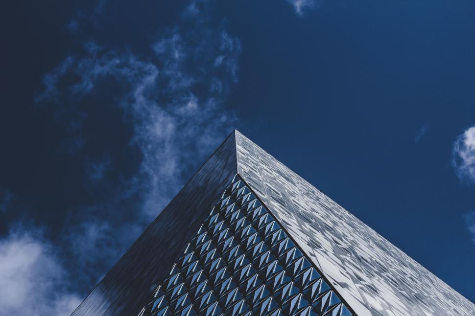 Free Image of Modern building with glass facade pointing towards the blue sky 