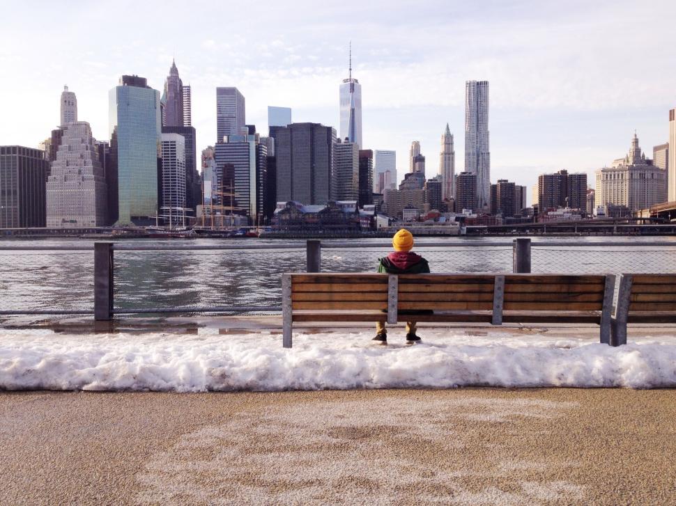 Free Image of Person Sitting on Bench Overlooking City Skyline in Winter 