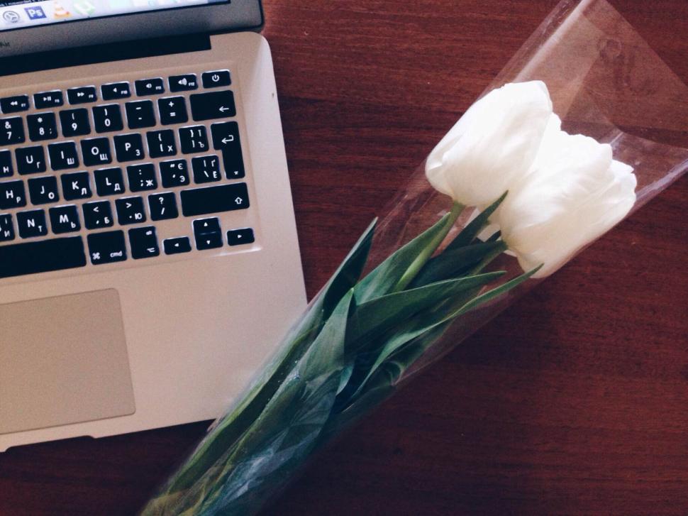 Free Image of Tulips on a desk next to a laptop in a calm and neat setup 
