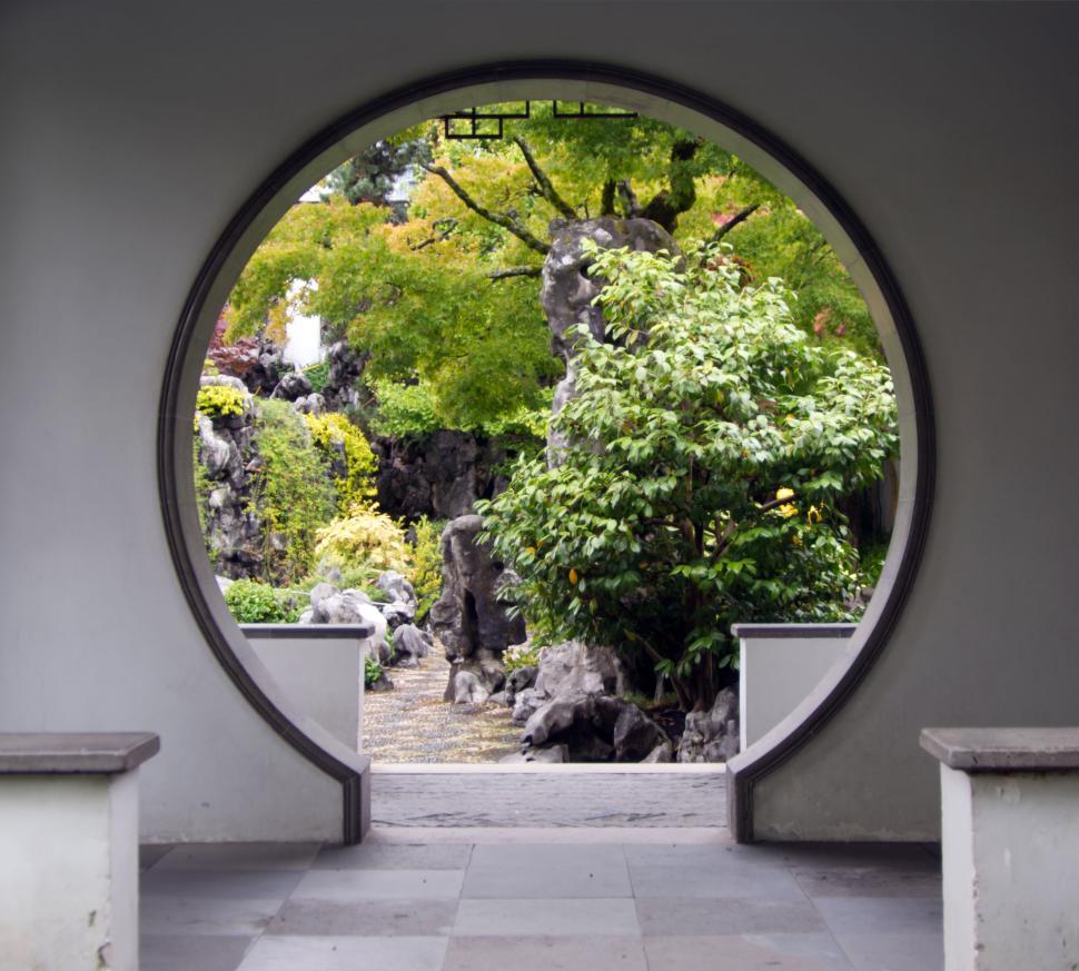 Free Image of Circular doorway opening to a lush traditional Japanese garden. 