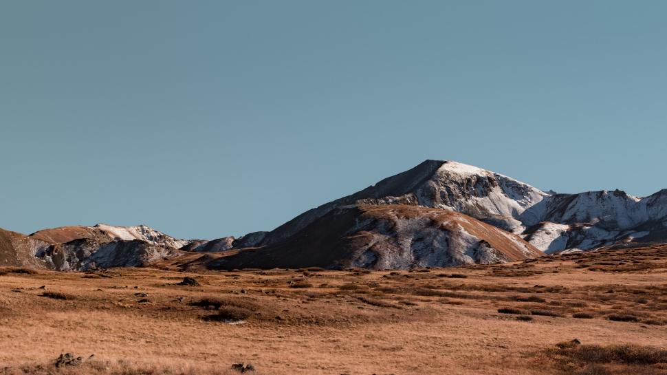 Free Image of Expansive view of rolling mountain landscape, clear sky 