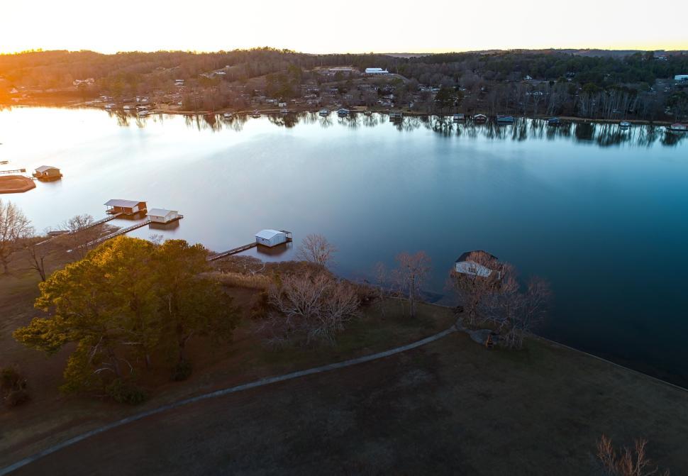 Free Image of Aerial view of calm lake at sunset with scattered homes. 