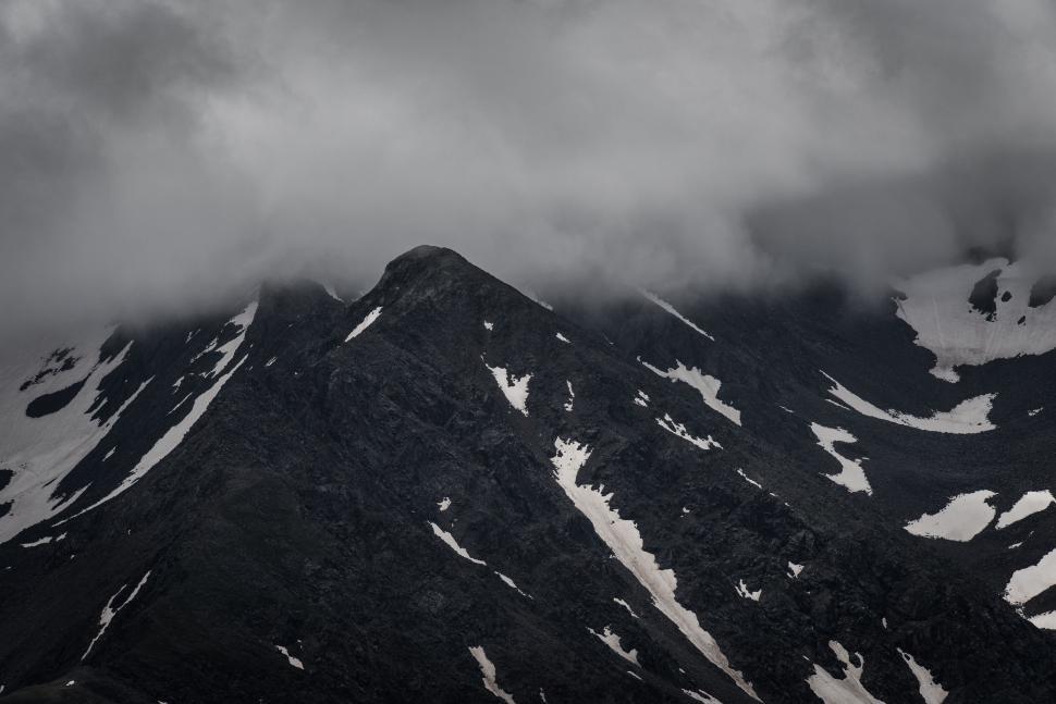 Free Image of Dark mountain peaks covered with patches of snow 