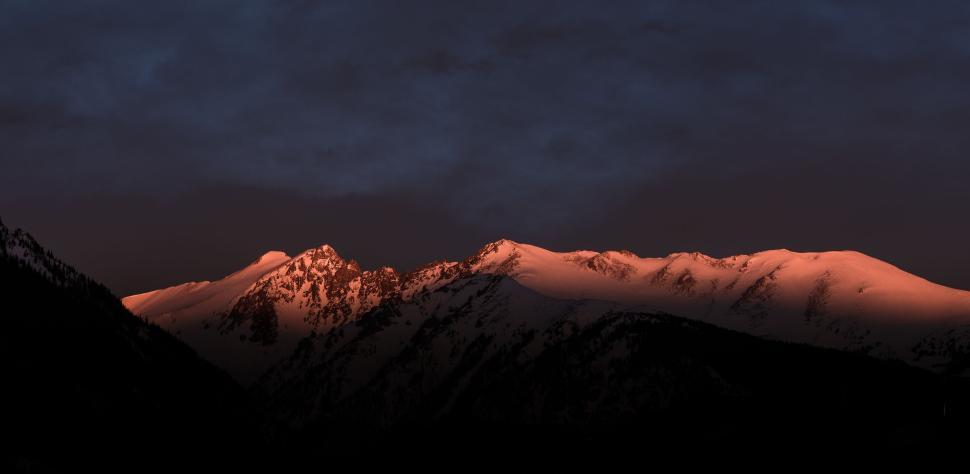 Free Image of Sunlit mountain range at dusk with glowing snow 