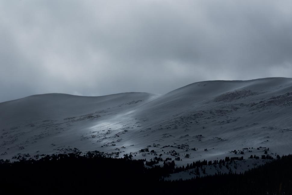 Free Image of Calm snowy hills under an overcast sky at dusk 