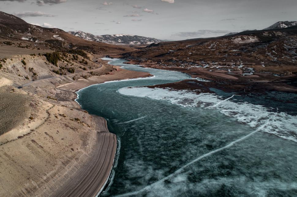 Free Image of River curving through rocky landscape with snowy mountains 