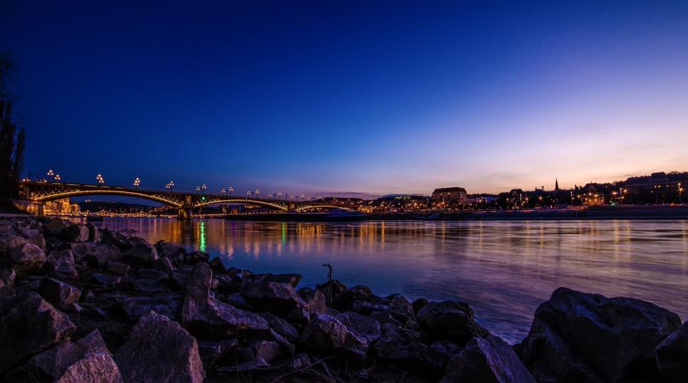 Free Image of Night view of beautifully illuminated bridge spanning calm river. 