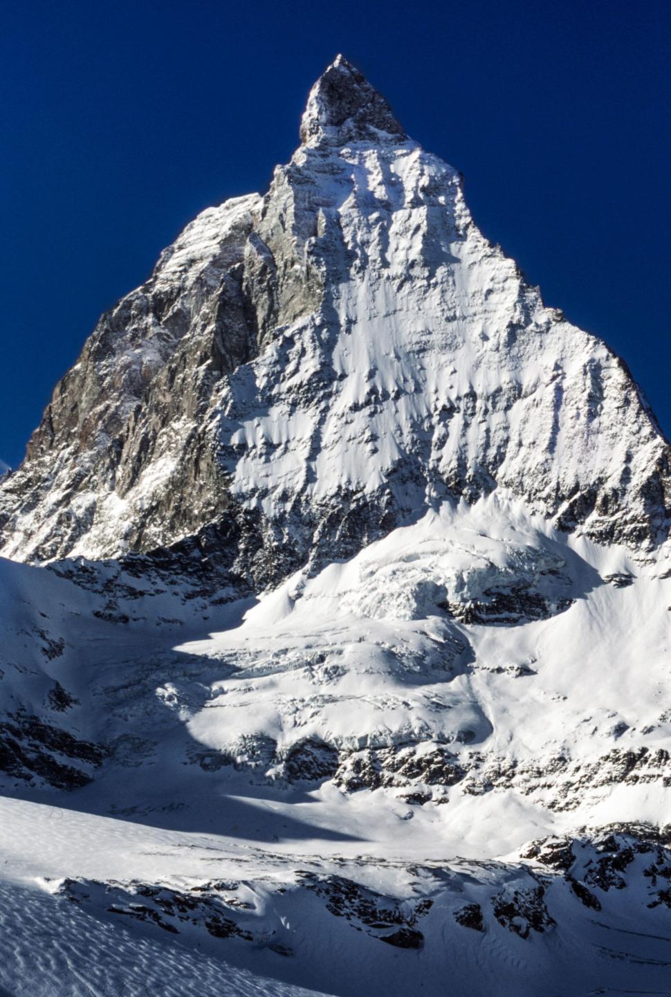 Free Image of The Matterhorn peak under clear blue sky with snow. 