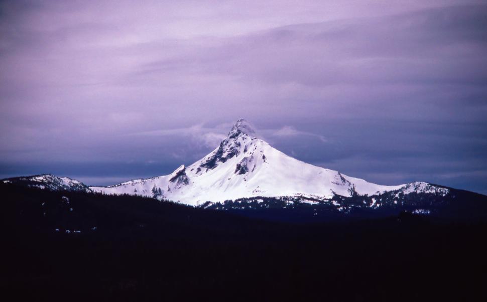Free Image of Snow-Covered Mountain Peak Under Overcast Sky 