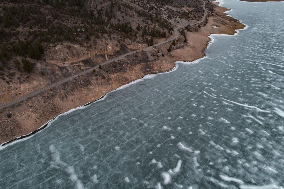 Free Image of Frozen lake by the forest mountain road in winter 