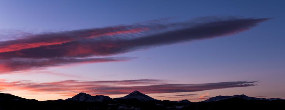 Free Image of Sunset mountain silhouette with colorful sky tones 