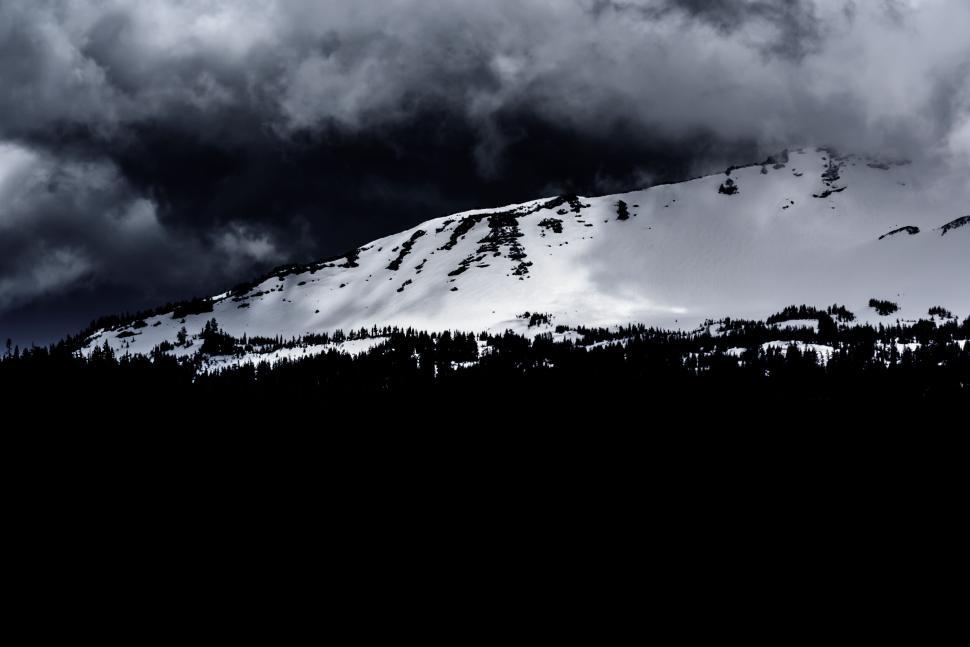 Free Image of Dramatic mountain landscape cloaked underneath dark clouds. 