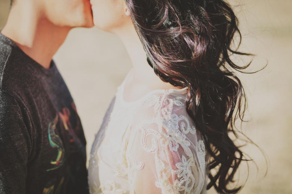 Free Image of Couple sharing a kiss, close-up with wind in hair 