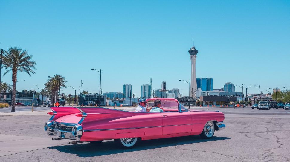 Free Image of Vintage convertible car driving through a cityscape 