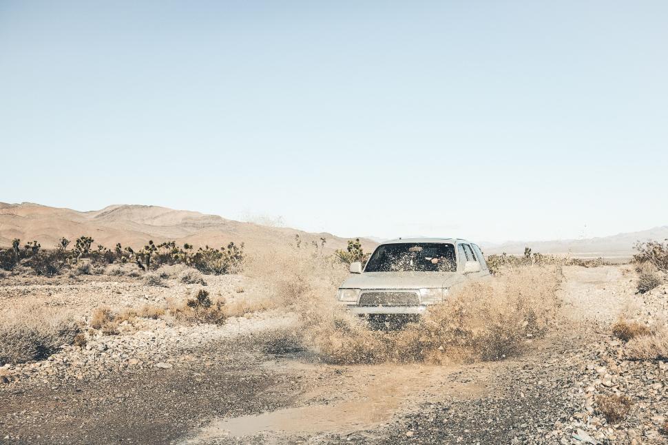 Free Image of Off-road vehicle splashing water on rocky terrain 