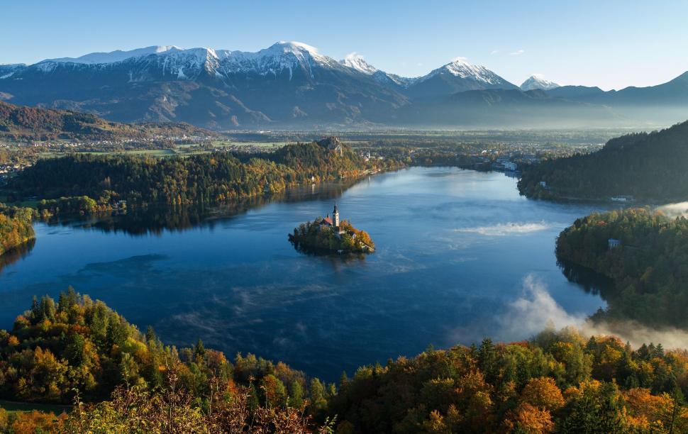 Free Image of Serene lake with island and mountains in the distance 