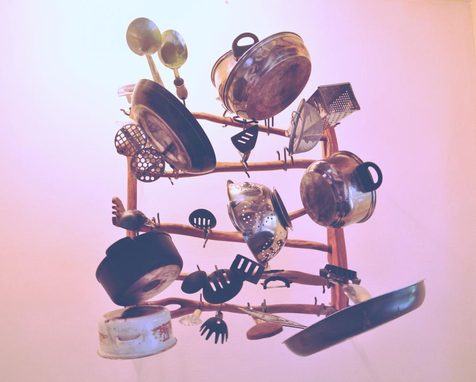 Free Image of Assorted kitchen utensils arranged on a pink wall. 