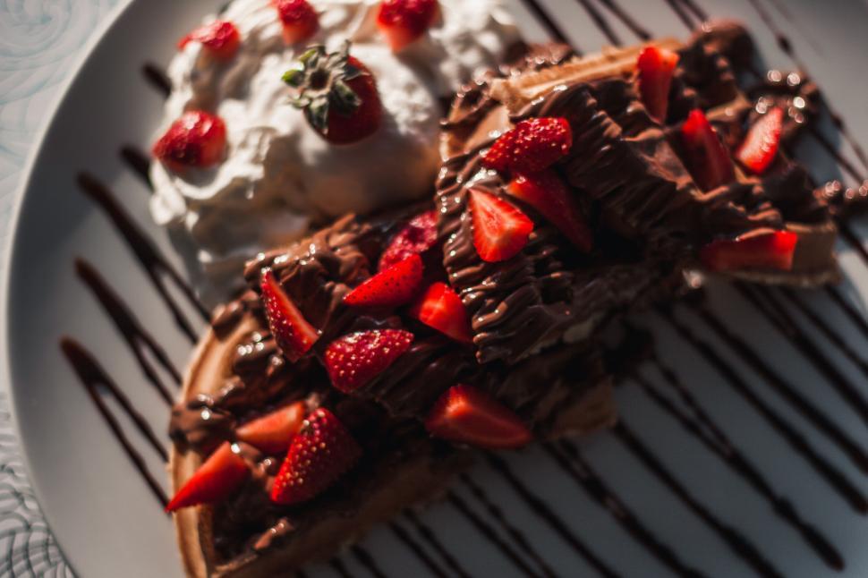 Free Image of Delicious waffles topped with strawberries and cream. 