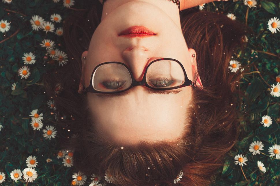 Free Image of Person lying in meadow of daisies during daytime 