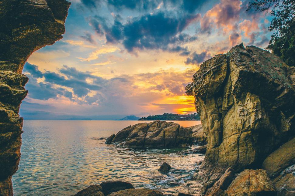 Free Image of Breathtaking sunset over rocky cliffs by the sea 