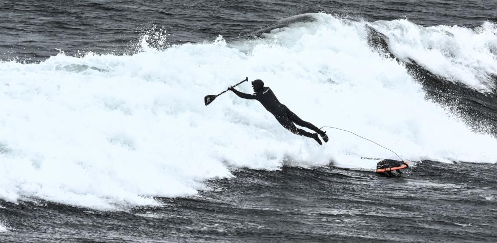 Free Image of Surfer leaping off the board with immense ocean waves. 