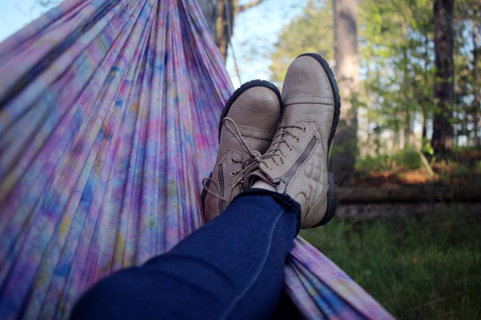 Free Image of Person wearing boots relaxing in a multicolored hammock. 