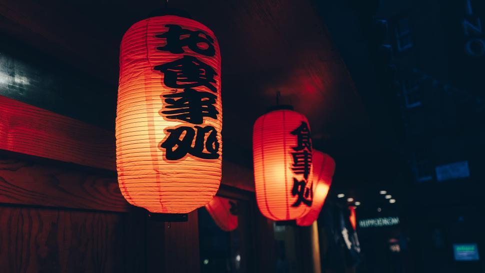 Free Image of Red lanterns with black writing hanging outside at night 