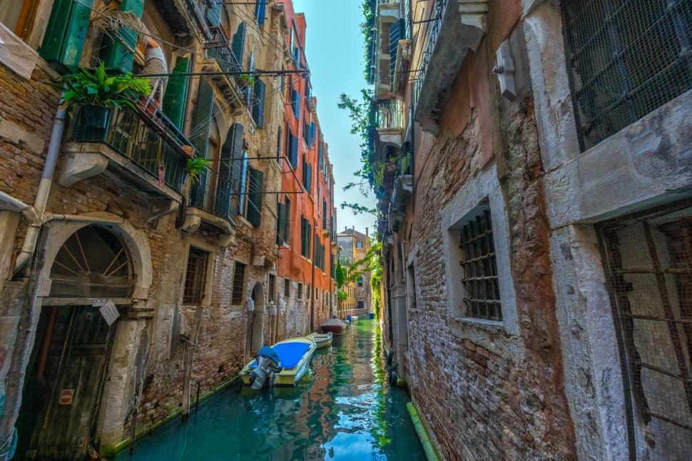 Free Image of Charming canal with boats surrounded by old buildings 