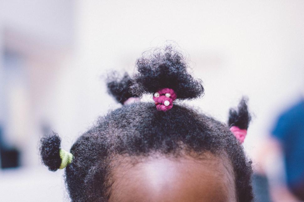 Free Image of Child s hair captioned with colorful hair ties in bunches. 