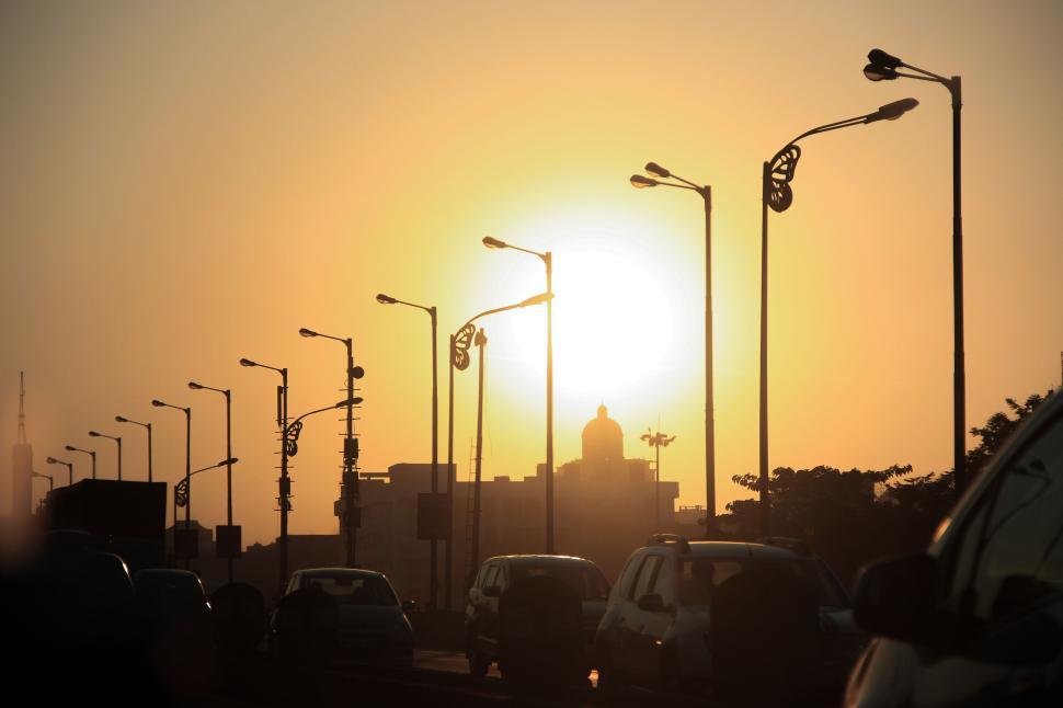 Free Image of Urban sunset with silhouettes of street lamps and cars. 