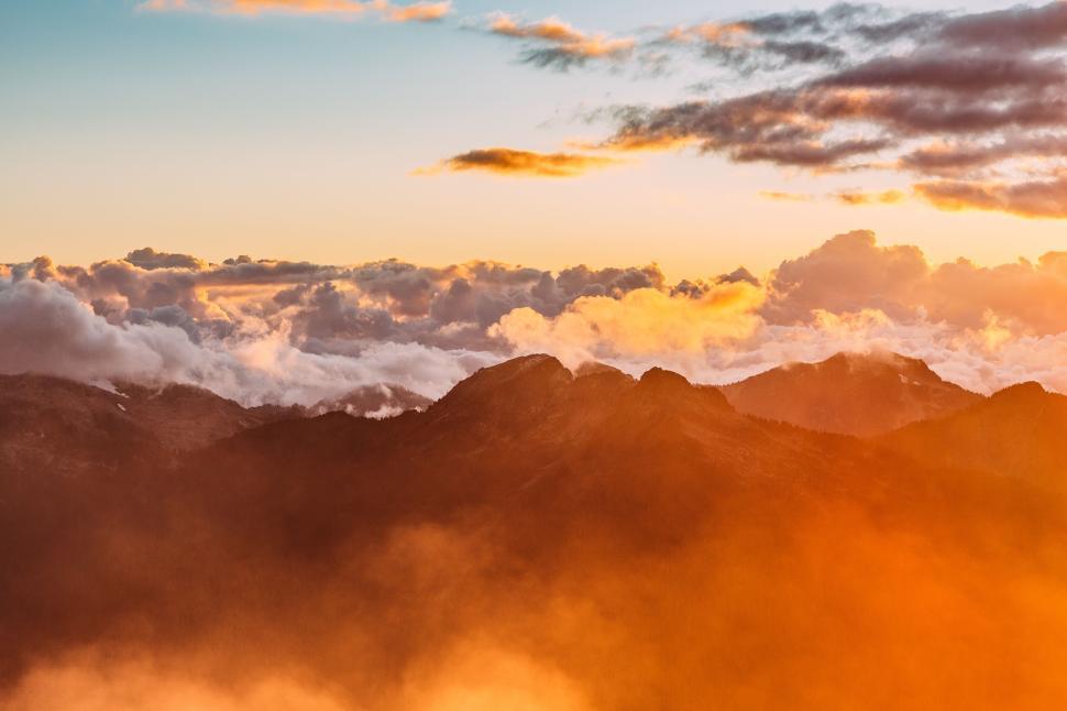 Free Image of Stunning sunrise over mountains with clouds and sky. 