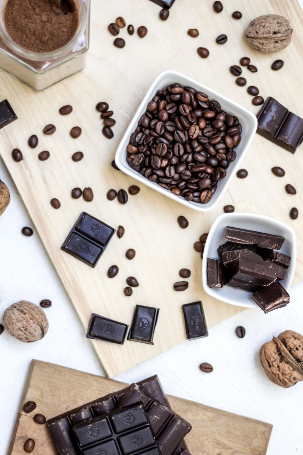 Free Image of Coffee beans and chocolate arranged on wooden board. 