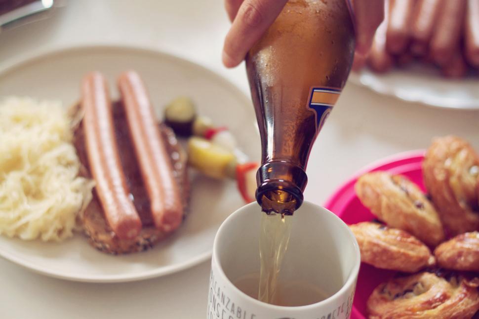 Free Image of Pouring beer into mug with sausages and pastries 