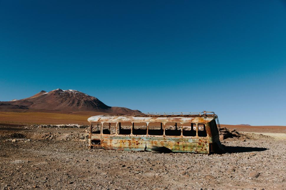 Free Image of Abandoned rusty bus in a desert landscape setting 