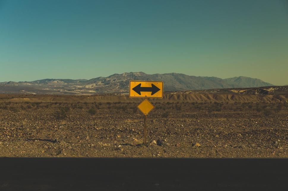 Free Image of Desert landscape with direction sign in foreground 
