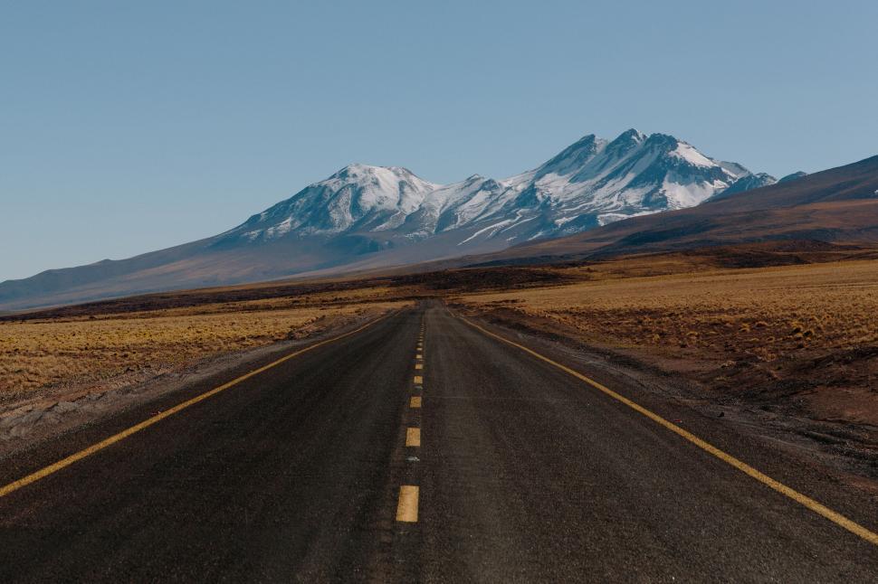Free Image of Deserted road with mountains in background under sky 