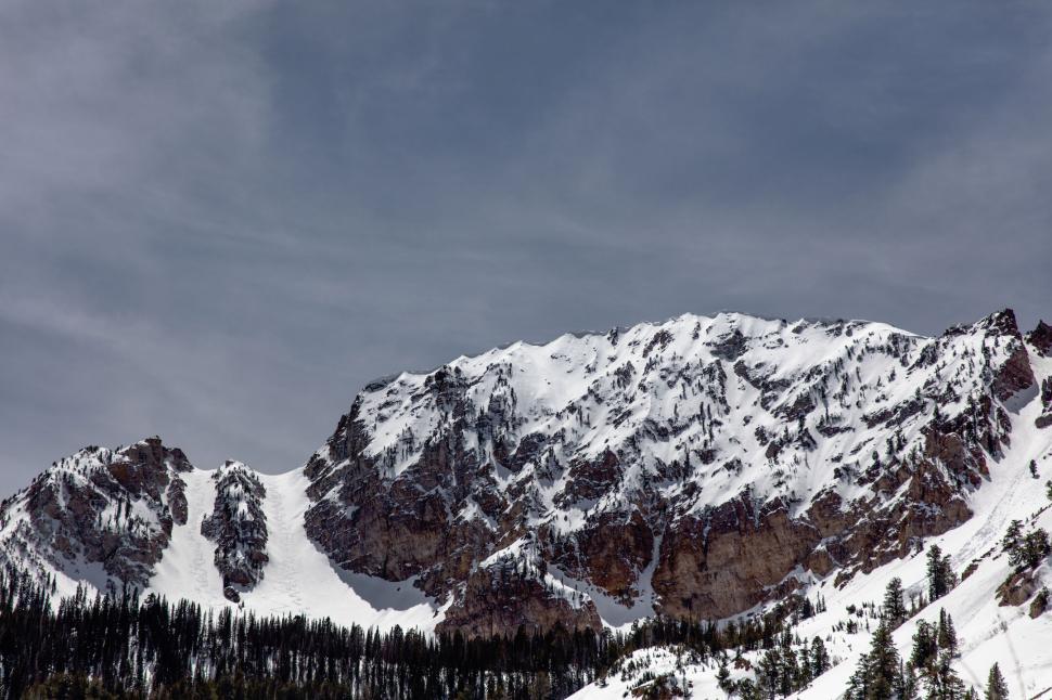 Free Image of Snowy mountain peak towering against gray sky 