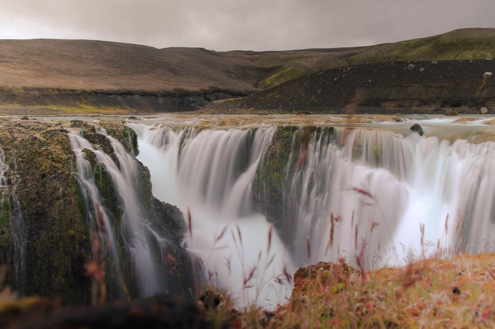 Free Image of Powerful waterfall cascading down rocky cliffs 