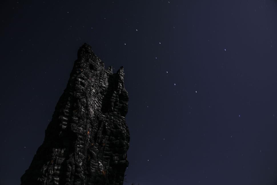 Free Image of Rock formation with stars twinkling in night sky. 