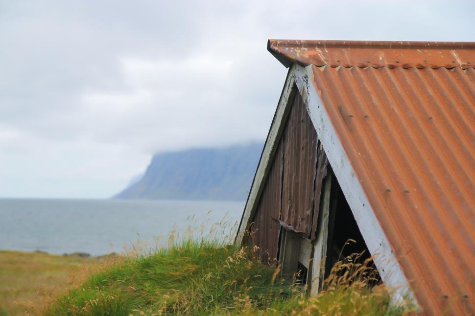 Free Image of Old shed by the sea with rusted roof in scenic landscape 