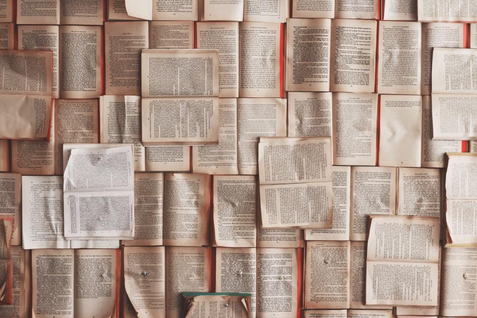 Free Image of A collage of open books with text laid out in layers 