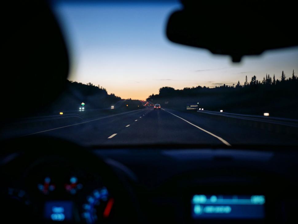 Free Image of Driving on highway at twilight with dashboard lights on. 